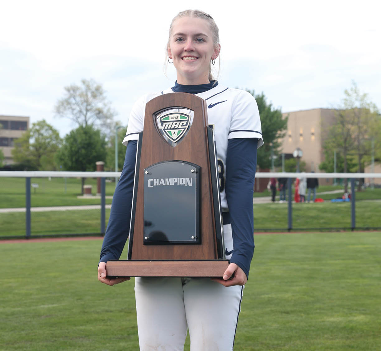 A girl holding a trophy. Description generated by AI