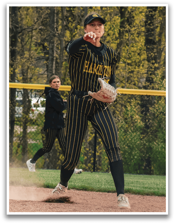 A woman in a black and yellow shirt is throwing a ball. Description generated by AI