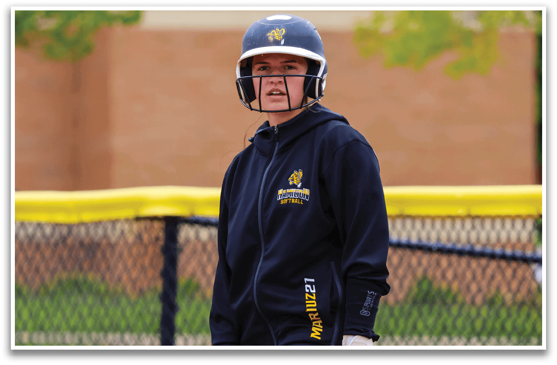 A person wearing a baseball helmet and holding a baseball bat. Description generated by AI