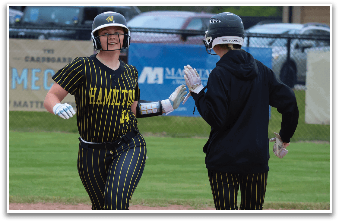 A woman wearing a black and yellow baseball uniform is running on the field. Description generated by AI