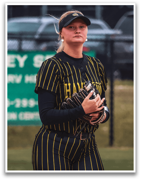 A woman wearing a baseball uniform and a hat. Description generated by AI