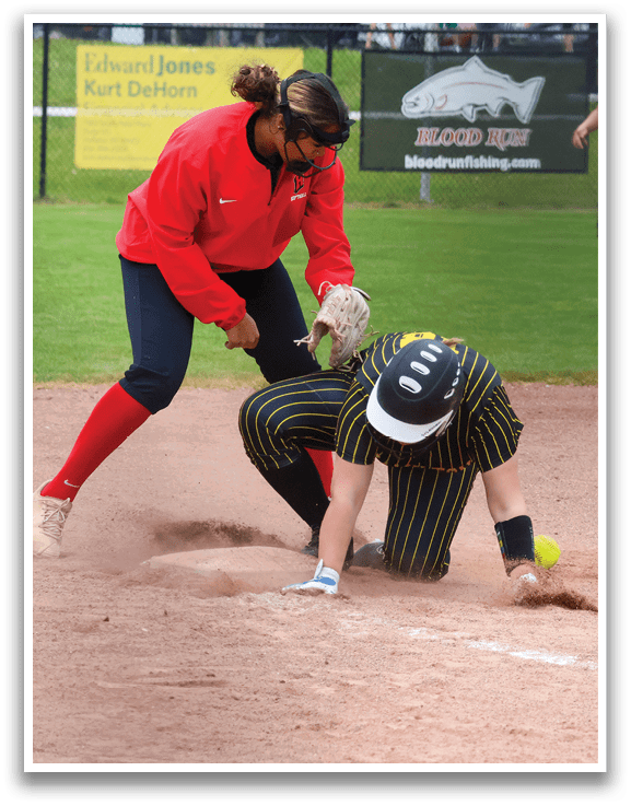 A woman in a red shirt is sliding into a base. Description generated by AI