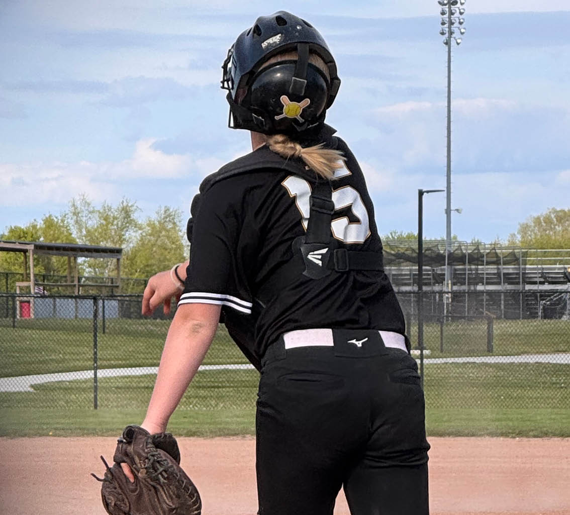 A girl wearing a black shirt and catching a ball. Description generated by AI