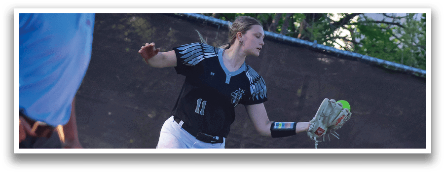A woman wearing a black and white shirt and white pants is throwing a ball. Description generated by AI