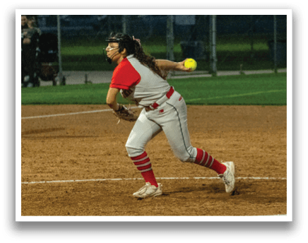 Two female softball players are playing on a field. One player is holding a bat and the other is holding a ball. They are both wearing red and white uniforms. AI generated content