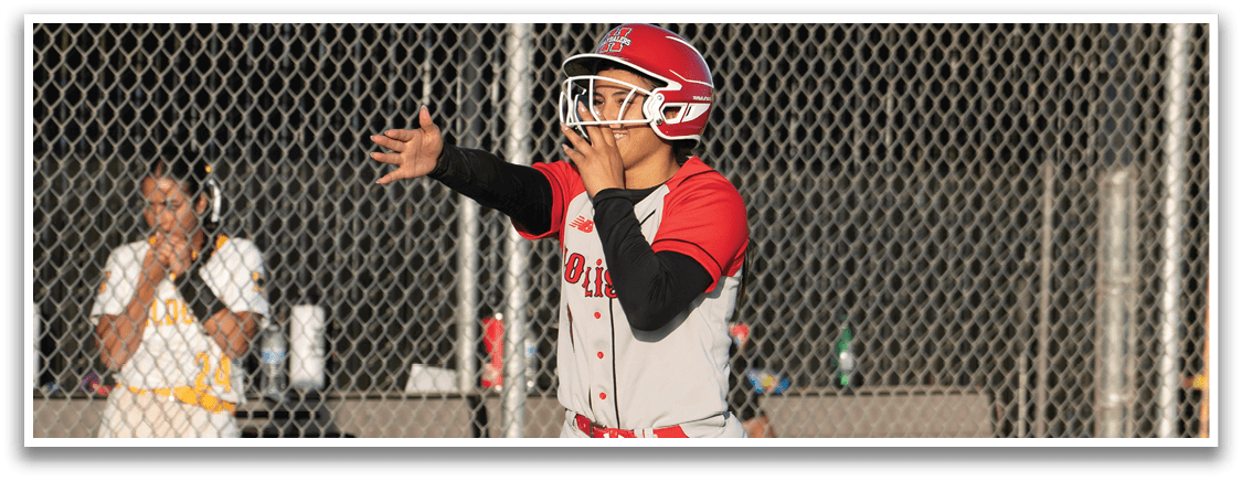 A woman wearing a white and red uniform is running on a baseball field. Description generated by AI
