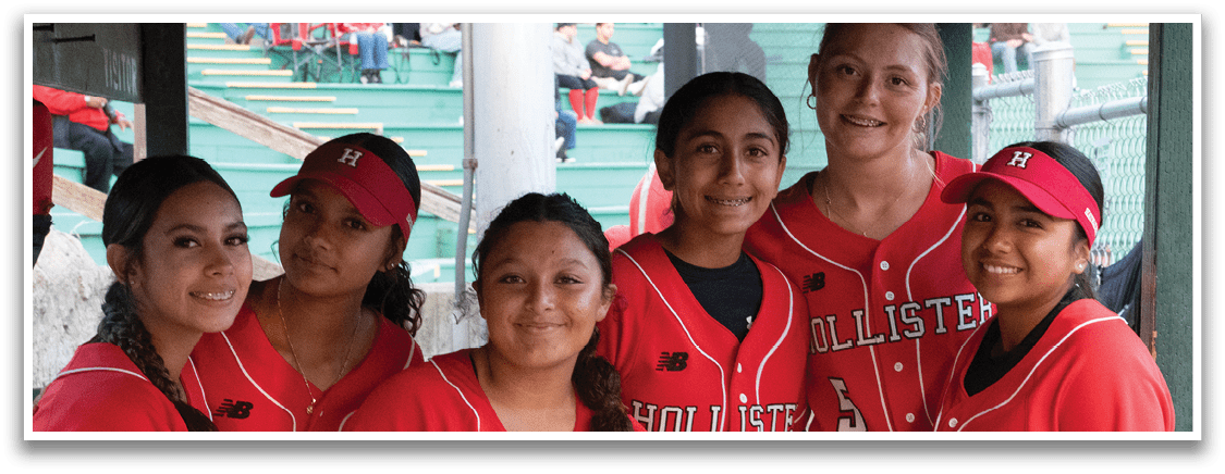 A group of girls wearing red and black jerseys. Description generated by AI