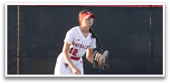 A baseball player wearing a red and white uniform is standing on a baseball field. Description generated by AI