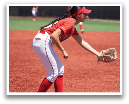 A woman wearing a red shirt and white pants is catching a ball. Description generated by AI