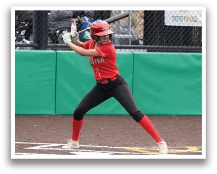 A woman in a red shirt and black pants is swinging a bat at a ball. Description generated by AI