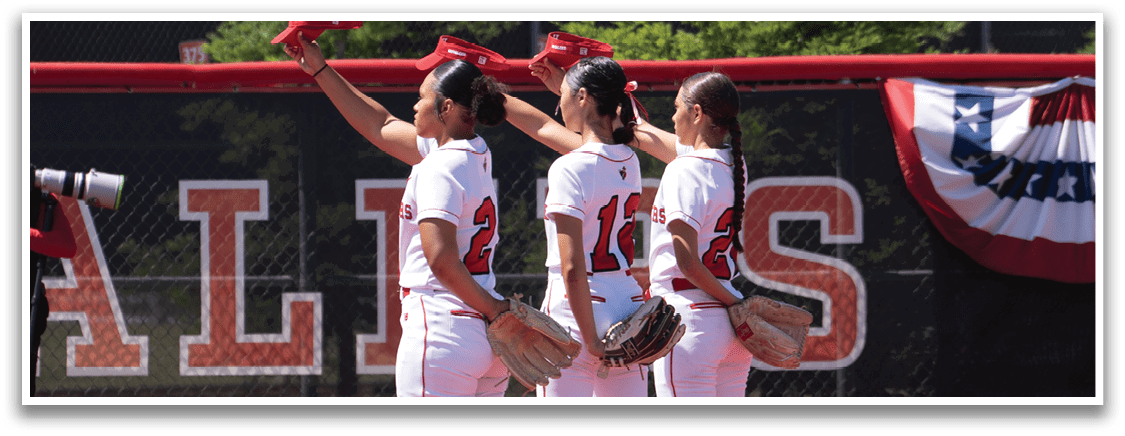 A group of girls standing on a baseball field. Description generated by AI