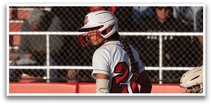 A baseball player is holding a bat and standing on the field. Description generated by AI