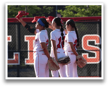 A baseball field with two girls standing on it. Description generated by AI