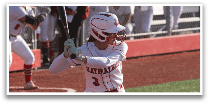 A female baseball player is swinging a bat at a ball. Description generated by AI