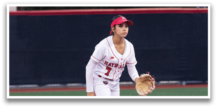 A baseball player wearing a red hat and white uniform is standing on a baseball field. Description generated by AI