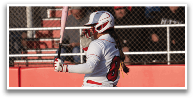 A female baseball player is swinging a bat at a ball. Description generated by AI