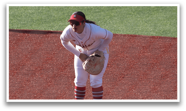 A baseball player in a white uniform is standing on the field. Description generated by AI