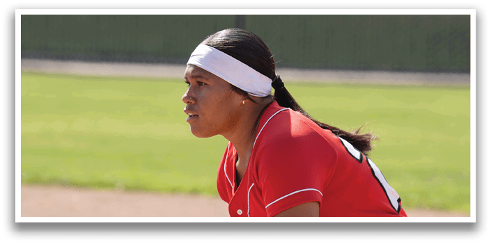 A female baseball player is swinging a bat at a ball. Description generated by AI