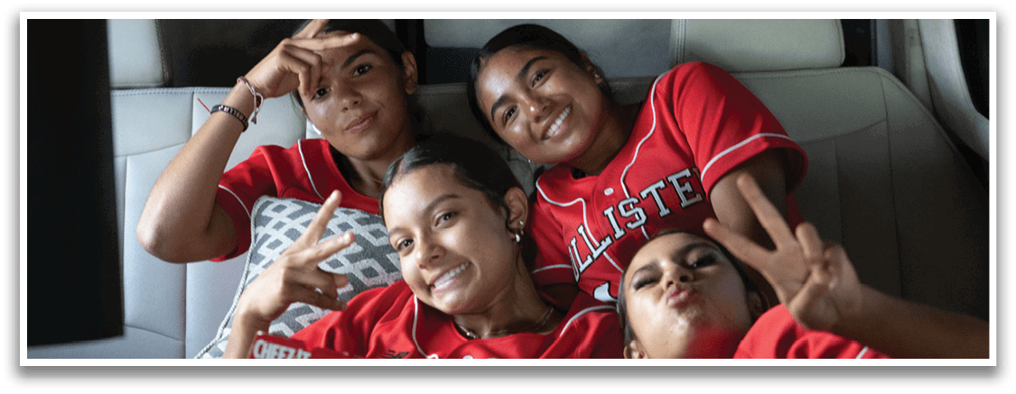 A woman wearing a red and white baseball uniform is holding a catcher's mitt. Description generated by AI