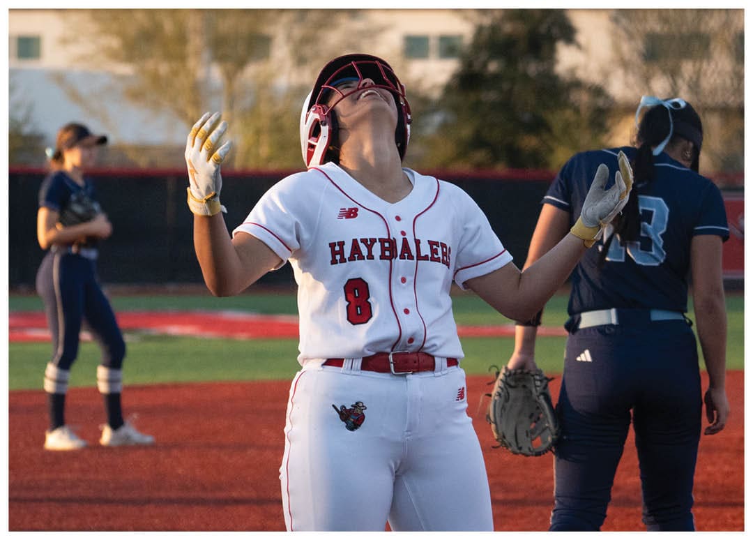 A female baseball player is holding her glove up to the sky, possibly celebrating a play. Another player is standing nearby, and a third player is in the background. AI generated content