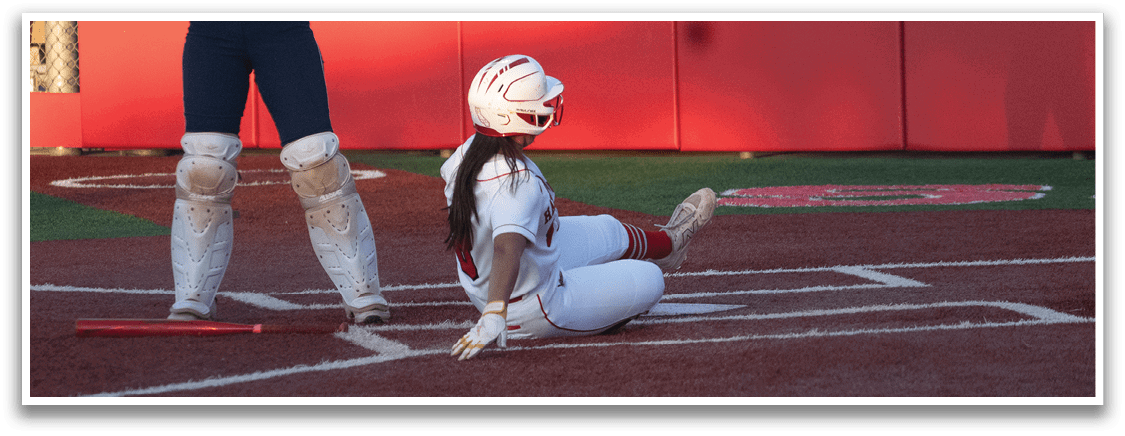 A female baseball player is sliding into home plate, while the catcher and umpire watch. AI generated content
