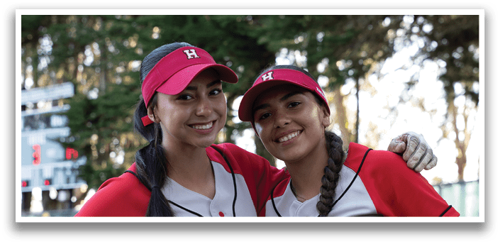 Two female baseball players pose for a picture. AI generated content