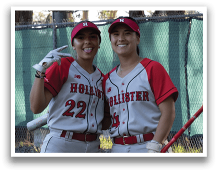 Two female baseball players standing on a field, one holding a bat. AI generated content