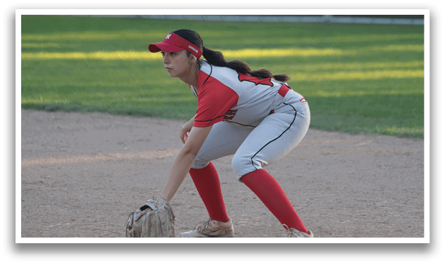 A woman wearing a red shirt and white pants is squatting on a baseball field, holding a baseball glove. AI generated content