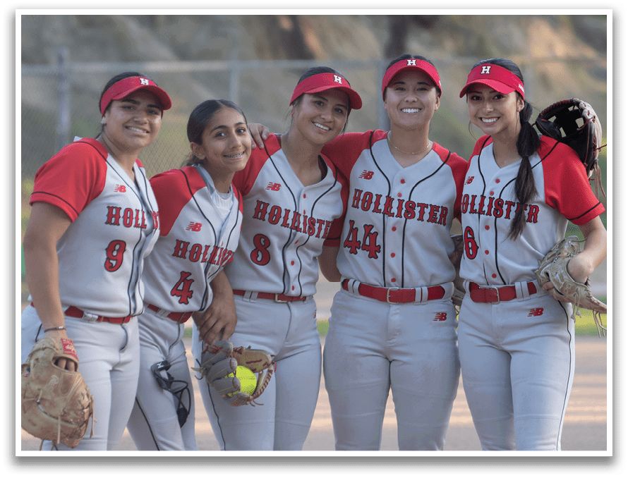 Four female softball players pose for a picture on a field. AI generated content