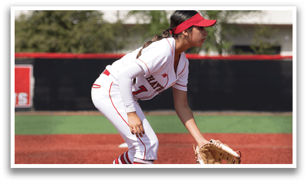 A female baseball player in a white and red uniform is ready to catch a ball. AI generated content