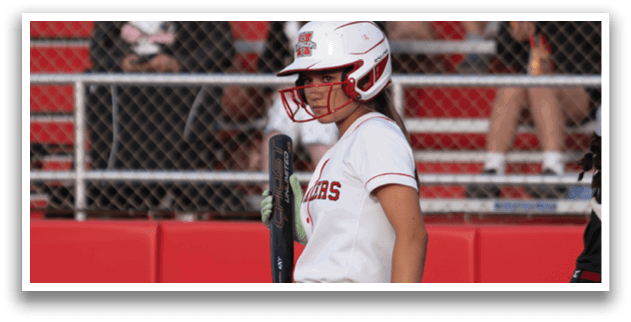 A female baseball player is standing on the field, holding a bat. AI generated content