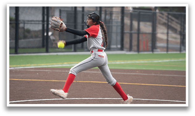 A woman wearing a grey and red baseball uniform is throwing a ball. Description generated by AI