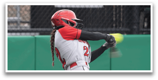 A girl is swinging a bat at a ball. Description generated by AI