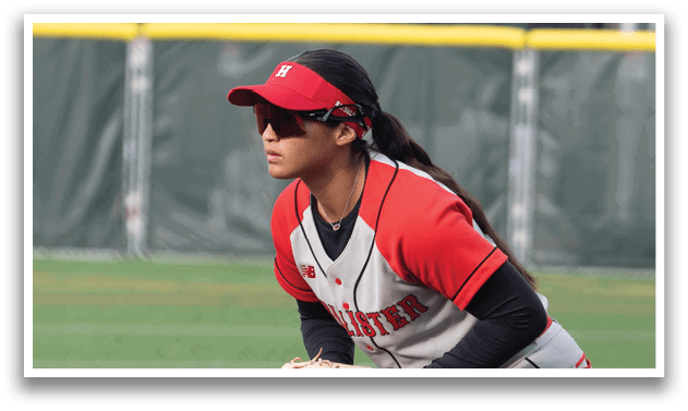 A girl in a red and white uniform is playing baseball. Description generated by AI
