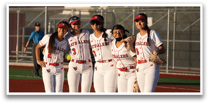 A group of female softball players standing on a field. Description generated by AI