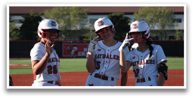 Three female baseball players wearing red and white uniforms. Description generated by AI