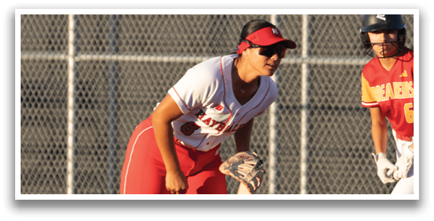 A woman is standing on a baseball field with a bat. Description generated by AI