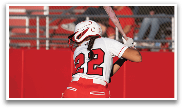 A female baseball player in a red and white uniform is swinging a bat. Description generated by AI