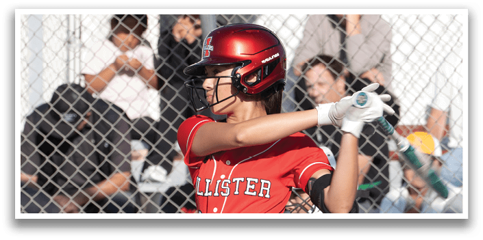 A girl in a red and black uniform is swinging a bat. Description generated by AI
