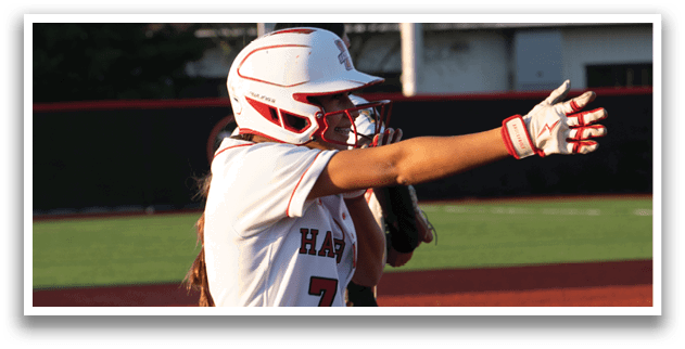 A female baseball player wearing a red and white uniform. Description generated by AI