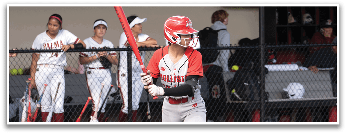 A girl is holding a bat and standing on a baseball field. Description generated by AI