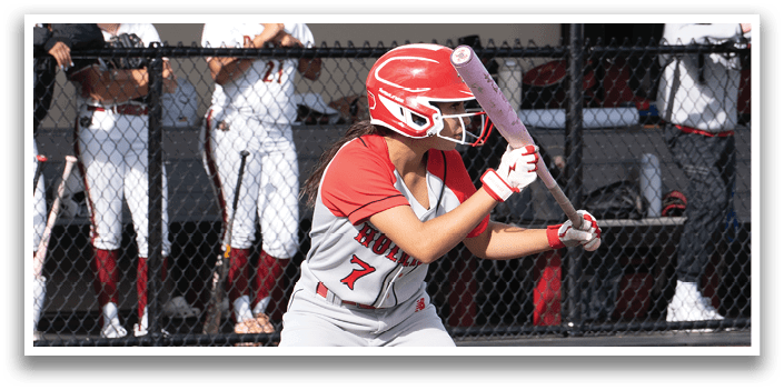 A girl is swinging a bat on a baseball field. Description generated by AI