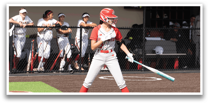 A woman is swinging a bat at a ball. Description generated by AI