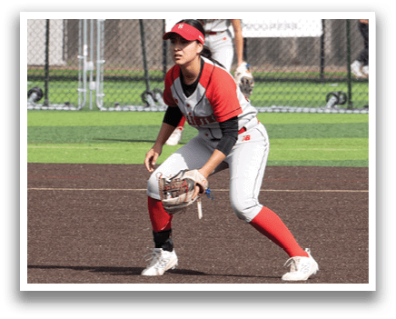 A woman in a red shirt and white pants is playing baseball. Description generated by AI