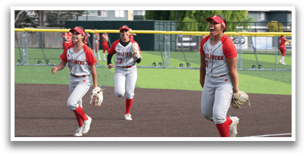 A group of girls playing baseball on a field. Description generated by AI