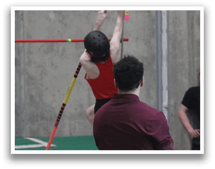 A man is jumping in the air to clear a pole, while another man watches. AI generated content