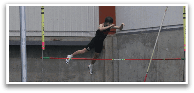 A man is jumping over a pole in a gym, wearing a black shirt and black shorts. AI generated content
