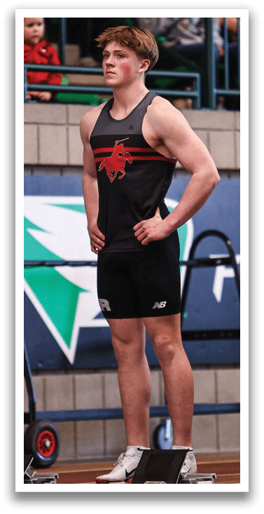 A man wearing a black shirt and shorts stands on a platform. Description generated by AI