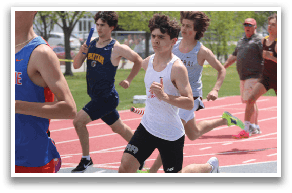 A group of young men running on a track. Description generated by AI