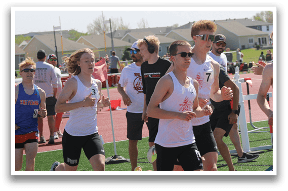 A group of people running on a track. Description generated by AI